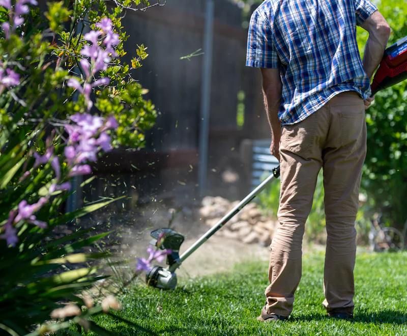 A landscaper trimming the edge of a lawn